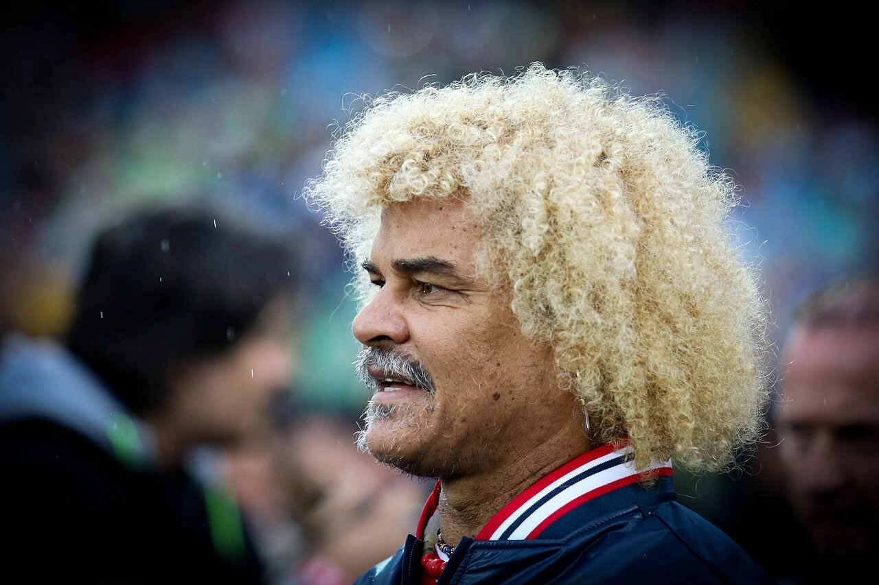 Carlos Valderrama in a candid editorial photo, shown in profile with his distinctive curly blond hair.